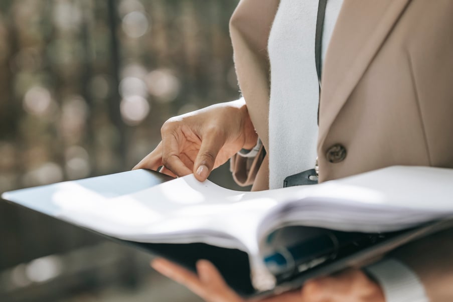 Crop businesswoman looking through documents